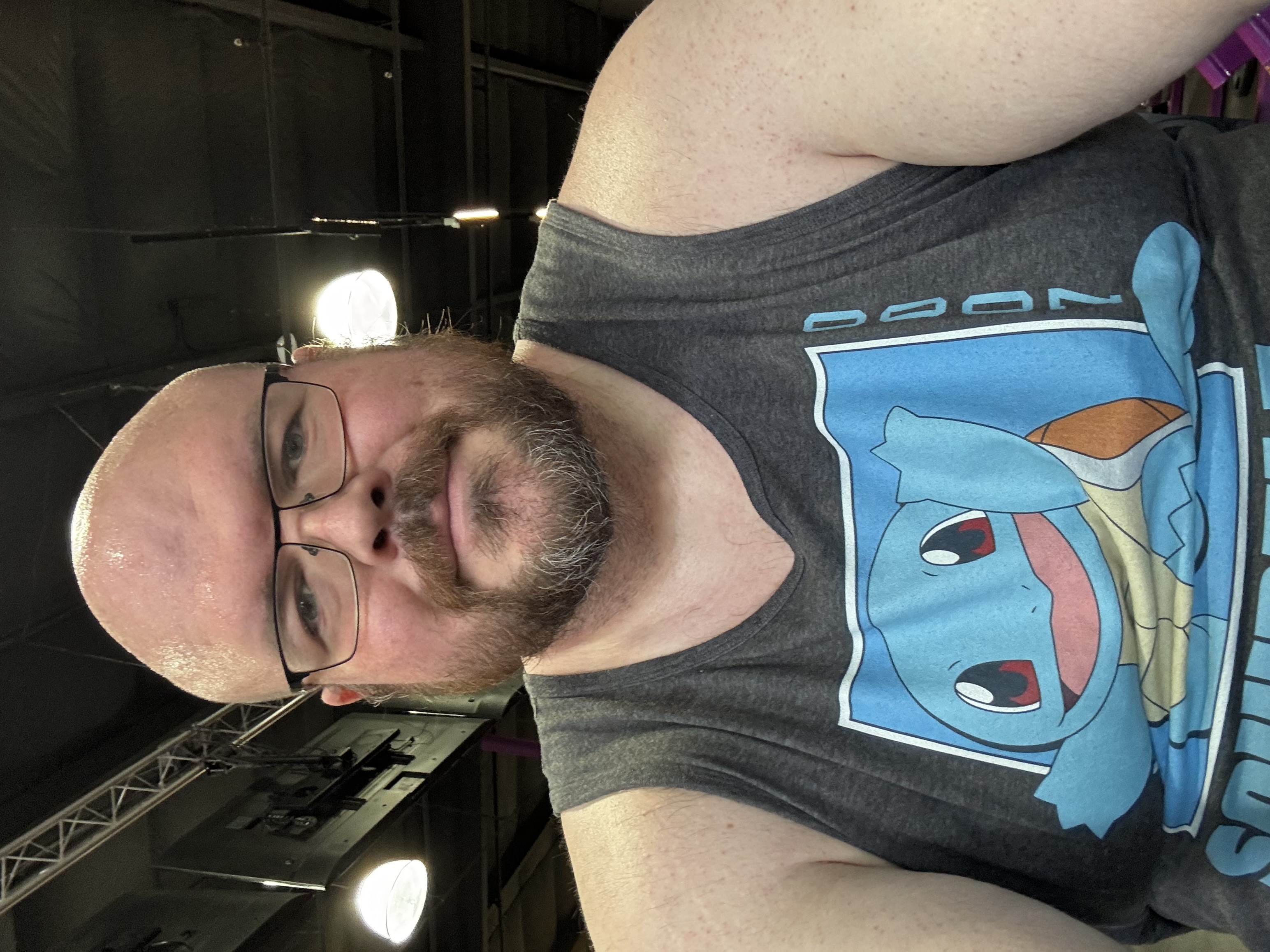 Sly Panorama at the gym in a Squirtle graphic tank top, glasses, and beard.